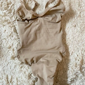 SKIMS Seamless Sculpt Thong Bodysuit - Skims bodysuit med string, storlek XXS. Aldrig använd, endast testad en gång. Färgen är Clay. Skickas i orginalförpackning.