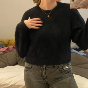 Svart stickad tröja - Säljer en mysig svart stickad tröja som är perfekt för kyliga dagar. Tröjan har en normal passform och långa ärmar. Den är enkel men stilren och passar till det mesta i garderoben.