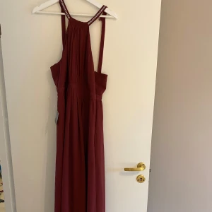 Röd balklänning  - En röd balklänning som inte kom till användning. Lappen sitter kvar och den är endast testad! Superfin i ryggen!! köpt på Nelly för 3-4 år sedan