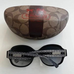  Coach solglasögon - Super snygga coach solglasögon i fint skick. Litet märke på ena glaset och ett knarrande ljud på fodralet annars i toppen skick! 