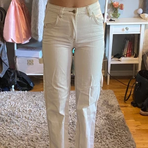 Vita cargojeans - Vita jeans med fickor på sidorna, har sprättat upp sömmarna vid fötterna för att de skulle bli längre