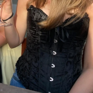 Korsett - Säljer dena svarta korsetten med söta detaljer som en snörning av sidenband framtill🌟 Sparsamt använd så den är i ett gott skick!