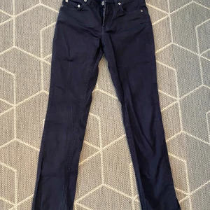 Mörkblå jeans från Filippa K - Säljer ett par snygga mörkblå jeans från Filippa K i modellen Niki Twill. De är tillverkade av 98% bomull och 2% elastan, vilket gör dem både bekväma och stretchiga. Perfekta för både vardag och fest!
