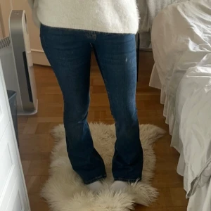 Mörkblå lågmidjade bootcut jeans - Säljer dessa snygga lågmidjade jeansen från Gina i en mörkblå nyans. Stolek 32 men passar även 34 då de är stretchiga. Formar sig verkligen efter kroppen och sitter såå fint bak!!😍😍