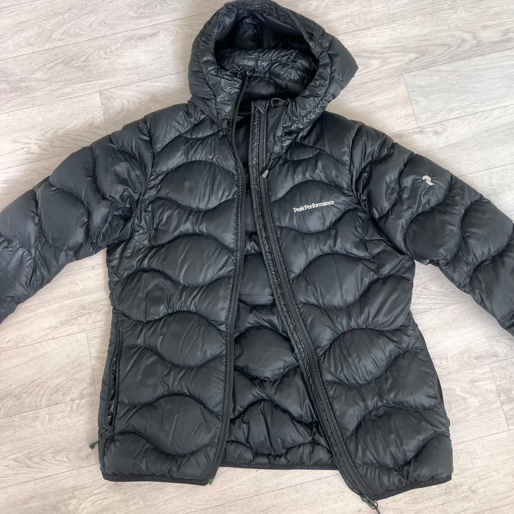 Jätte fin Peak performance dunjacka i storlek S, super fint skick. Inga defekter! Ganska tunn men varm!  I modellen: W HELIUM DOWN HOOD JACKET BLACK Färgen är svart men kan upplevas som marinblå i vissa ljus! Nypris: 2999,  Mitt pris: 1899💕. Jackor.