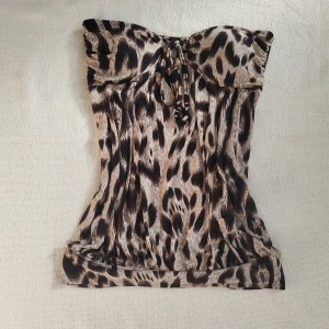 Leopard festtopp - Super snygg tubetopp med leopardtryck. Över bröstet finns en guldfärgad detalj med kristaller. Den saknar en kristall men är inget man märker av. 