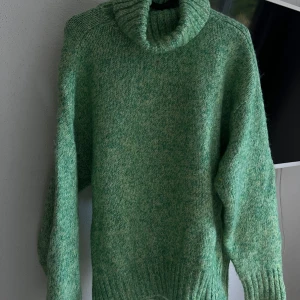 Grön stickad polotröja från Zara - Säljer en supermysig grön stickad polotröja från Zara. Perfekt för kyliga dagar med sin varma och sköna känsla. Tröjan har långa ärmar och en ribbad kant vid ärmslut och nederkant. Den är i storlek S och passar perfekt för höst och vinter. Ett måste i garderoben för alla som älskar stil och komfort! 🍃