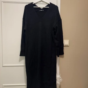 Svart klänning från BikBok - Snygg svart klänning från BikBok i storlek S. Klänningen har en v-ringad design och långa ärmar, perfekt för en stilren look. Materialet är mjukt och bekvämt, vilket gör den idealisk för både vardag och speciella tillfällen.