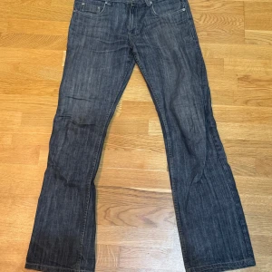 Gråa jeans från Super Human - Snygga gråa jeans från Super Human med klassisk femficksdesign och kontrastsömmar. Perfekta för en avslappnad stil. Midjan är normal och passformen är straight.