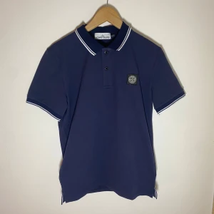 Stone Island pikétröja  - FÖRSTA TILL 500 ELLER HÖGSTA ERBJUDANDET INNAN SÖNDAG VINNER! ✅	•	Marinblå Stone Island pikétröja 	•	Ikonisk logotyp på bröstet 	•	Klassisk och stilren design 	•	Storlek: M 	•	Perfekt skick!