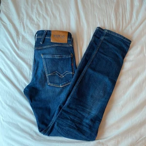 Blå jeans från Replay - Snygga blå jeans från Replay, modell Anbass. De har en slim fit passform och klassisk femficksdesign med dragkedja och knapp. Perfekta för en stilren look.