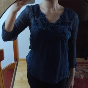 Blå blus  - En V-urringad mörkblå blus med grön underton. Genomskinlig (jag har ett linne i första bilden). Inte använd, inga defekter, köpt secondhand