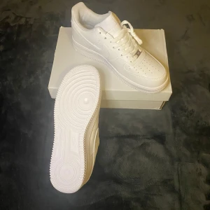 Vita Nike Air Force 1 - 	FÖRSTA TILL 1000kr ELLER BÄSTA ERBJUDANDET INNAN MÅNDAG VINNER! ✅•	Vita Air Force 1 	•	Klassisk och tidlös design 	•	Storlek: 44 EU 	•	I fint skick!