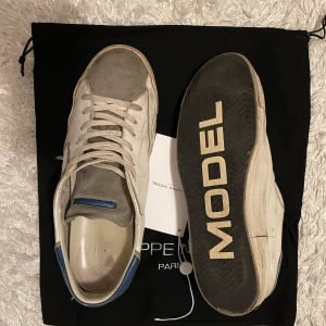Philippe model - Snygga Philippe Model sneakers i grått med blå detaljer. Köpta för 1 år sedan på cettire för 3300. Inget hål eller något på skon som är trasigt, bara lite märken som hör till modellen. Priset är ej hugget i sten så hör av dig 