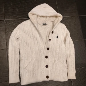Pälsfodrad Ralph Lauren cardigan  - Säljer en cardigan från Ralph Lauren med luva i storlek M. Väldigt varm och mysig perfekt nu till kallare väder. Cardiganen är pälsfodrad och i fint skick. Skriv vid minsta fundering.