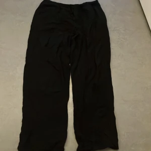 Svarta byxor från Gina Tricot - Säljer ett par svarta linnebyxor från Gina Tricot i storlek XS. Byxorna har en loose passform och är tillverkade i ett mjukt material. De är även uppsydda, så om nån har nån fråga eller behöver en bild på nåt så är det bara att säga till! Kan alltid diskuteras om pris.