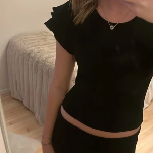 Svart topp från Zara - Snygg svart topp från Zara med korta ärmar och volangdetaljer. Perfekt för en stilren look. Tillverkad i ett mjukt material som ger en bekväm passform💗