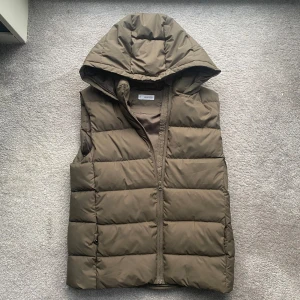 Dunväst med luva  - En riktig snygg dunväst med luva och en sjukt snygg olivgrön färg. Perfekt för lite varmare vinterdagar ❄️ | Skick: 9,5/10 ✅ | Hör av er vid fler frågor 🦦