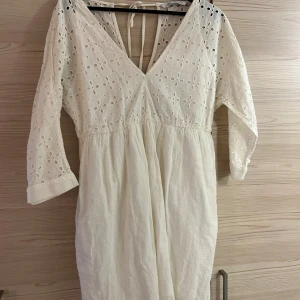 Vit klänning  - Jättefin vit klänning från Zara. Passar perfekt till studenten🤩broderad upptill och textur i tyget nedtill med 2 fickor😍Halvlånga ärmar och relativt  kort går att knyta som man vill i ryggen!! 