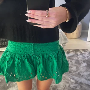 Grön zara kjol - Snygg grön kjol med broderade detaljer och volang. Kjolen har en kort längd och knappar framtill.💕