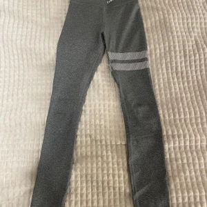 Grå leggings från Stronger, har aldrig använt  - Snygga grå leggings från Stronger med elastisk passform. Tillverkade i en blandning av polyester och elastan för extra komfort. Designade i Sverige med stilrena detaljer på benet.