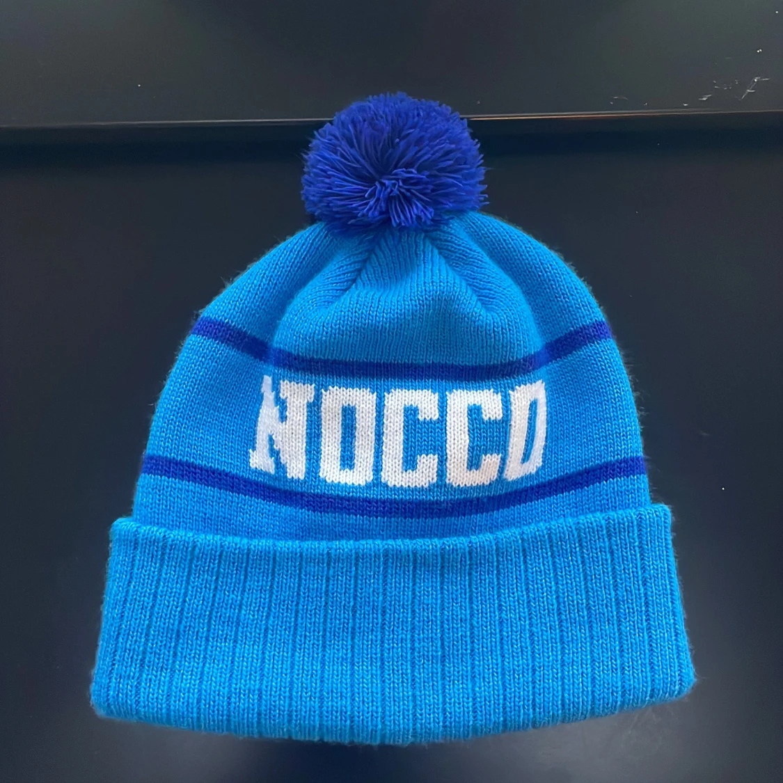 Ljusblå mössa med tofs från NOCCO