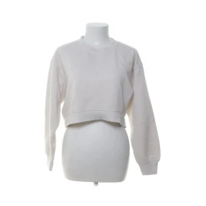 Vit croppad sweatshirt - Säljer en stilren vit croppad sweatshirt med långa ärmar. Perfekt för en avslappnad look. Passar bra till jeans eller kjol. Använd max 1 gång🥰