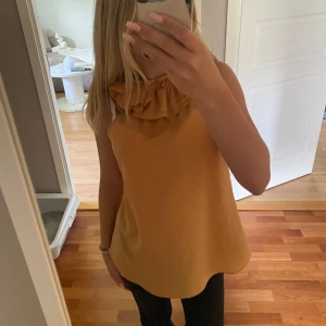 Zara topp - Snygg gul ärmlös topp med volangdetalj vid halsen. Perfekt för varma dagar och kan enkelt matchas med olika outfits. Passar till allt! Skriv för frågor💕