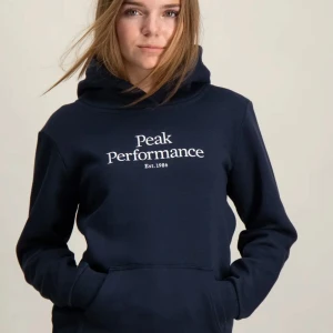 Peak Performance hoodie - En mörkblå/marinblå peak performance hoodie, knappt använd, ser ut som ny unre urtvättad elle flocket elle npgot alls skick 10/10 (äkta) storlek 170 men jag som har storlek 164 så passar dme perfekt men passar även min syrra perfekt som hwr storlek 170, Skriv flr fler frågor 