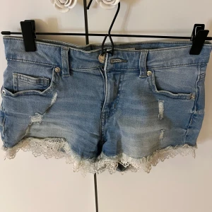 Blå jeansshorts med spetsdetaljer - Sälger mina nästan oanvända shorts med spetsdetalier. 