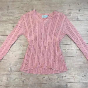 Rosa stickad tröja  - Säljer en söt rosa stickad tröja från Morris lady med kabelstickat mönster och v-ringning. Tröjan har långa ärmar och ribbade kanter, perfekt för kyliga dagar. Passar både till jeans och kjol!