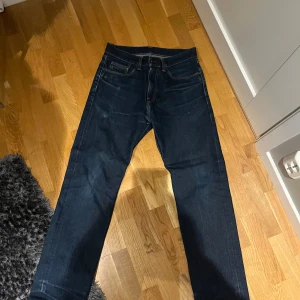 Mörkblå jeans från Carhartt - Snygga mörkblå jeans från Carhartt med klassisk femficksdesign. De har en rak passform och är perfekta för en avslappnad stil. Märkeslogga på bakfickan ger en extra touch. Storlek 30 32 Pris blir såklart billigare vid snabb affär!