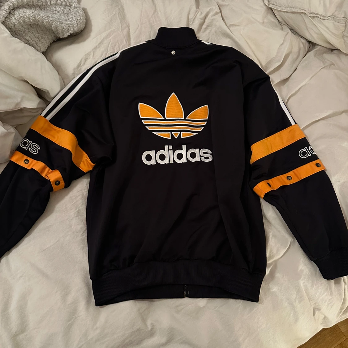 Svart och orange jacka från Adidas. Tunn.  - 91