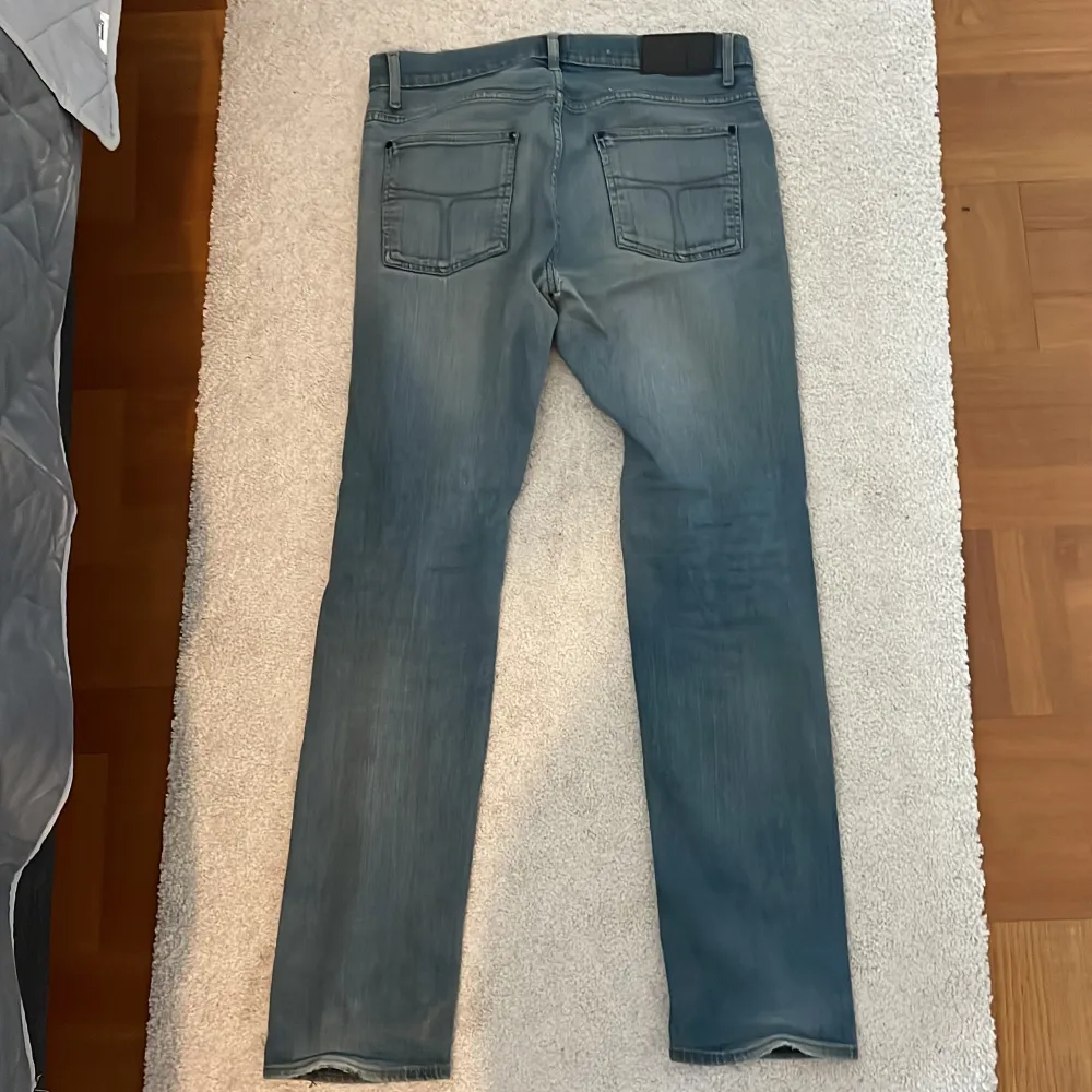 Säljer ett par riktigt schyssta jeans från tiger of Sweden. I bra skick förutom hålet i grenen som syns på 3e bilden, men borde lagas lätt. I stretchigt material, ett av de skönaste jeansen jag haft på mig. I storlek 34/34 men sitter mindre. Blågrå . Jeans & Byxor.