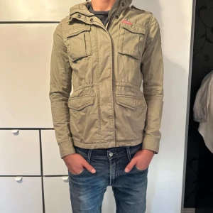 Fieldjacka - Nu säljer jag denna sjukt snygga field jackan från Superdry. Vilket är dunder för hösten🍁 och våren🌹Jackan är 9/10 i skick, storlek S. Modellen på bilden är 181cm 68kg. Vid minsta fundering eller behov av fler bilder, är det bra att höra av dig.😀