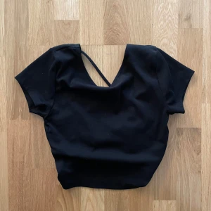 Svart topp  - Svart topp med öppen rygg från Gina Tricot. Oanvänd med prislapp kvar 