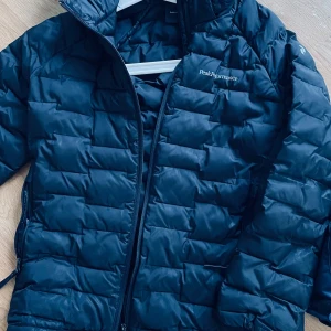 Peak performance jacka  - Svart peak performance jacka stl 150 junior. Fint skick, finns två lagningar med svart tejp men inget som påverkar. 