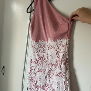Klänning - Ljusrosa kort klänning med spets och en arm. 
