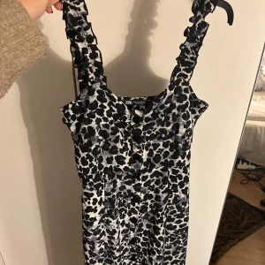 Lång leopard klänning - En lång leopard klänning ifrån Zara. Jättefint skick. Knappar på framsidan av halva klänningen som går att knäppa upp så vill man ha den mer öppen går det också. Jättebra skick och otroligt fin på. Säljer den för att den tyvärr har blivit för liten.