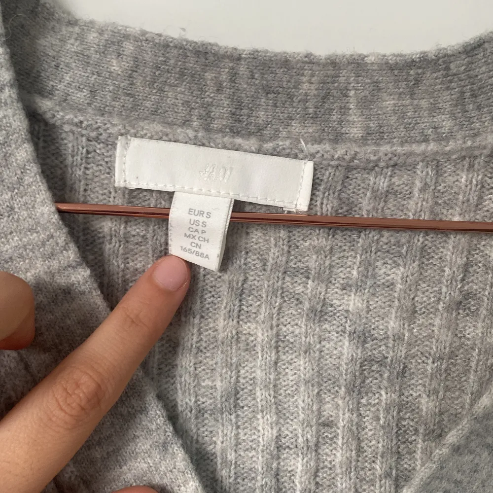 Säljer en supermysig grå ribbad kofta från H&M. Den har en v-ringad design med stora knappar framtill och asymmetrisk. Passar även S och XS. Tröjor & Koftor.