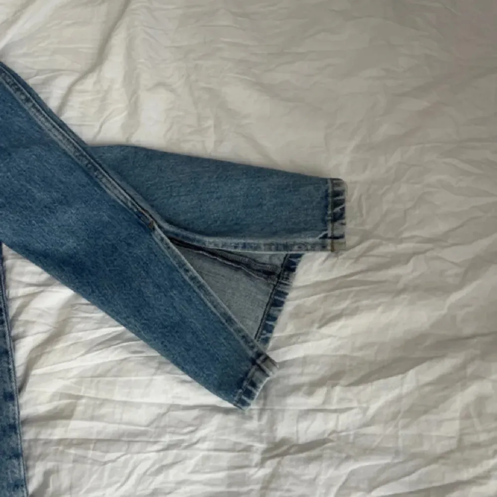 Säljer ett par snygga blå jeans med slits bra i längd på mig som är 170 cm. Jeans & Byxor.