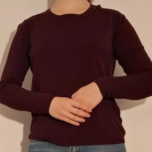 Vinröd långärmad tröja med dragkedjedetalj - Vinröd långärmad tröja med dragkedjedetalj i nacken. Då taggen inte längre finns kvar är jag orsäker på tröjans storlek.    (Sista bilden visar tröjans material)