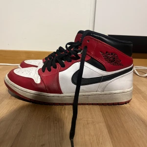 Nike Air Jordans i rött och vitt - Snygga Nike Air Jordans i klassisk röd och vit färgkombination med svarta detaljer. Skorna har snörning och en ikonisk design som passar perfekt för sneakerälskare.