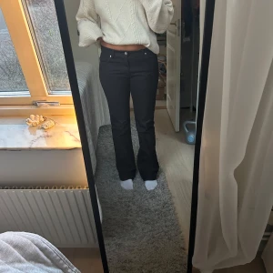 Svarta jeans bootcut - Snygga svarta jeans från Riley Jeans med en klassisk design. De har en bootcut passform och är lågmidjade, vilket ger en stilren look. Perfekta för både vardag och mer uppklädda tillfällen. Midjemått 80cm Innerbenslängd 83cm