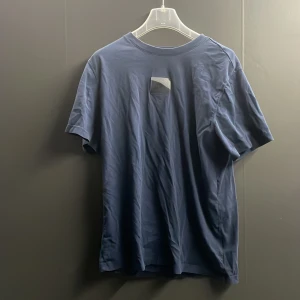 Mörkblå t-shirt från Nike - Snygg mörkblå t-shirt från Nike med 'AIR MAX' tryck i ljusblått på baksidan. Perfekt för en sportig look eller avslappnad stil. Tillverkad i mjukt material för extra komfort.