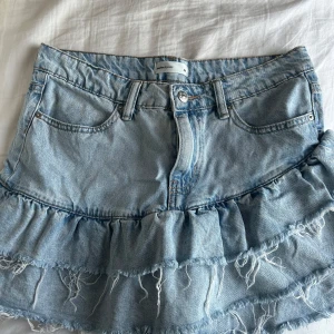 Blå jeanskjol med volang - Jättesnygg jeanskjol från Gina, endast använd ett fåtal gånger då den är för stor.