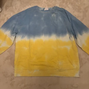 Tie dye sweatshirt  - Säljer en cool tröja från Pull & Bear, sitter oversized. Tröjan har ett snyggt tie-dye mönster i blått och gult. Perfekt för en avslappnad stil.