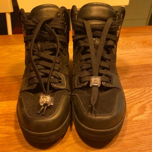 Svarta sneakers från Acne Studios - Snygga svarta sneakers från Acne Studios med hög modell och snörning. Skorna har en robust sula och Acne Studios-logga på baksidan. Perfekta för en stilren look.