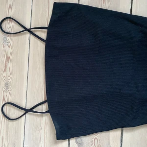Svart ribbad crop top från Monki - Snygg svart ribbad crop top från Monki med smala axelband! Storlek M/S
