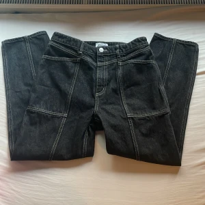 Svarta jeansbyxor från weekday - Snygga svarta jeansbyxor från Atticus med vita kontrastsömmar. Byxorna har en klassisk femficksdesign och raka ben. Perfekta för en stilren look.